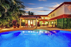A pool area with a covered seating area and a building with a red-tiled roof. - Hideaway & Harbour -2 minute walk to the beach (Fort Lauderdale)
