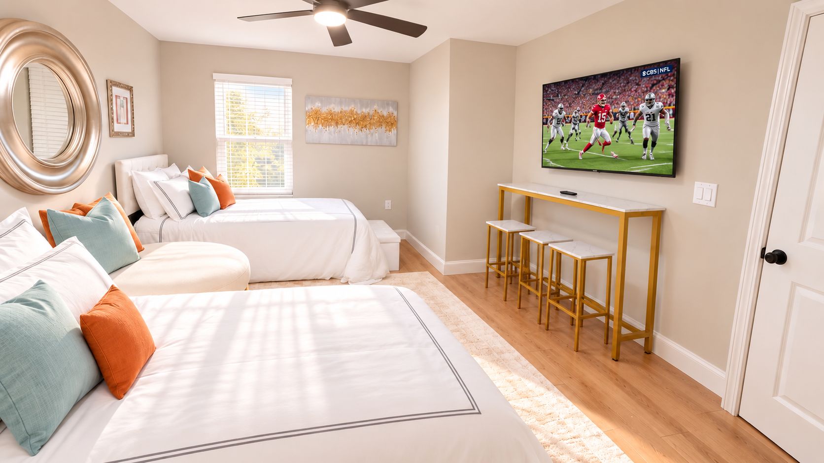 A bedroom with two beds, a TV, and a ceiling fan.