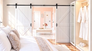 A bedroom with a bed, a bench, a wardrobe, and a sliding door.