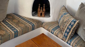 A corner seating area with a small wooden table and a decorative chimney.