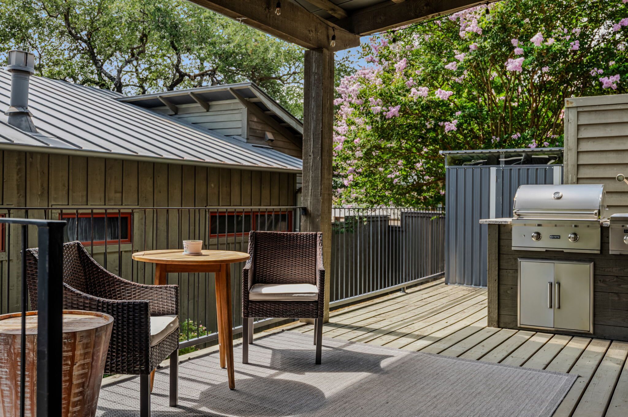 An outdoor patio with wicker furniture, a grill, and a covered area.