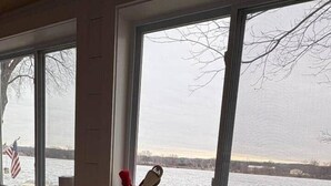 Une cuisine avec une fenêtre donnant sur un plan d’eau, un évier et un robinet.