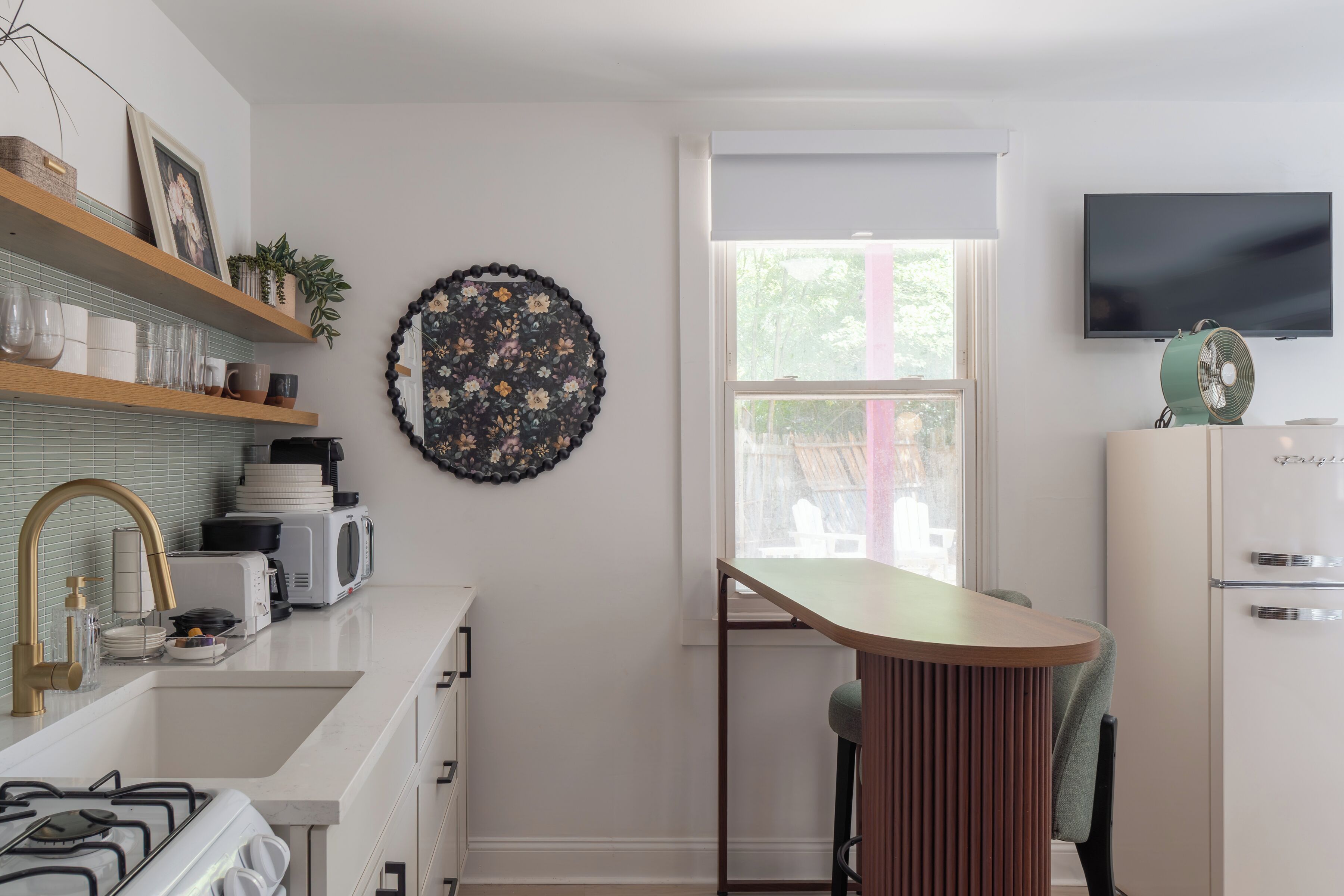 A modern kitchen with a gas stove, white cabinets, a microwave, and a decorative wall piece.