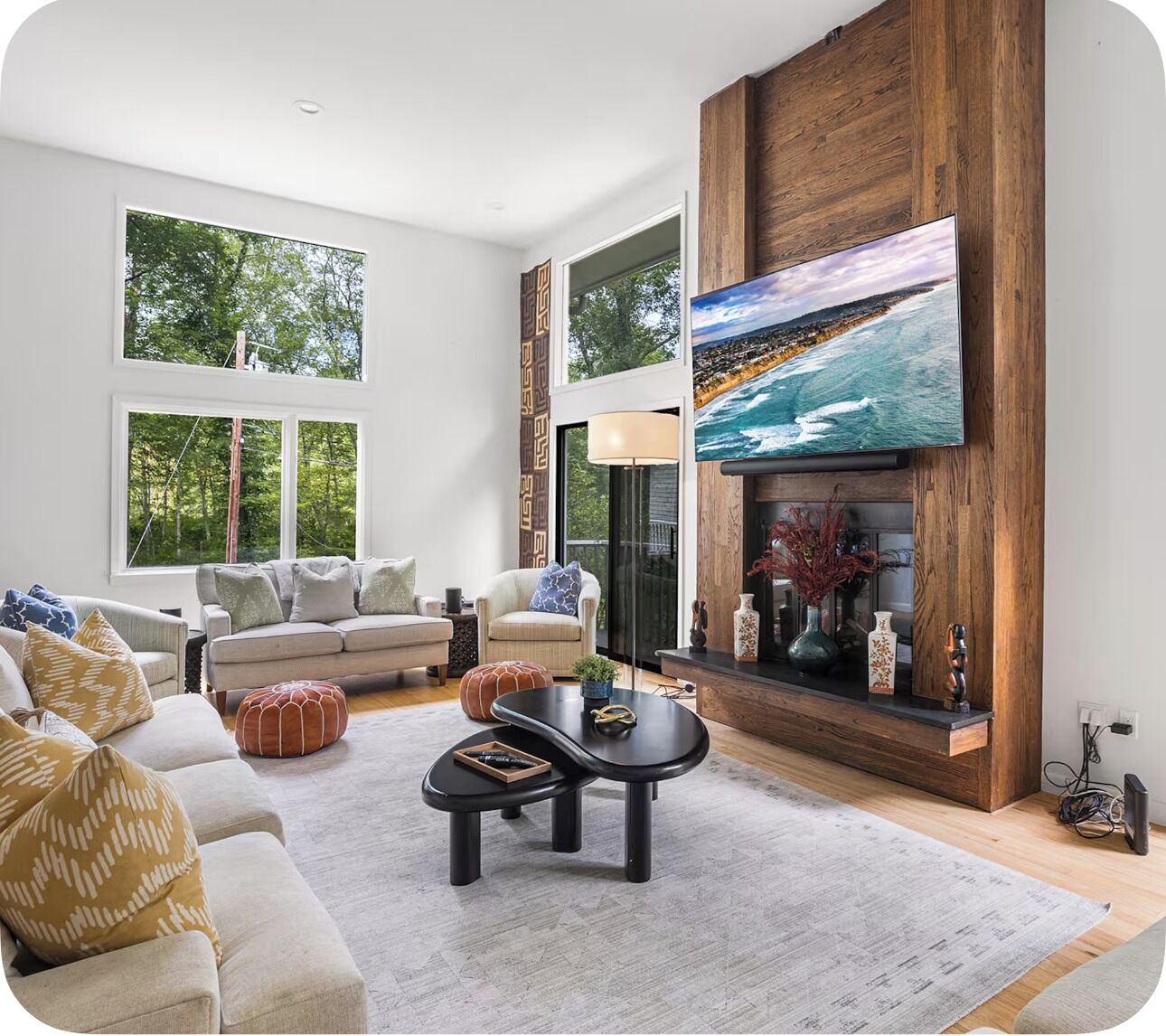 Una sala de estar moderna con un televisor de pantalla plana grande, una chimenea y un conjunto de sofás.