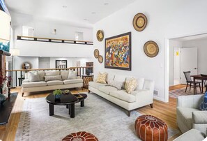A spacious living area with a high ceiling, a sofa set, a coffee table, and a dining area. - 3‑Acre Weston Retreat w/ Pool & Basketball Court (Weston)