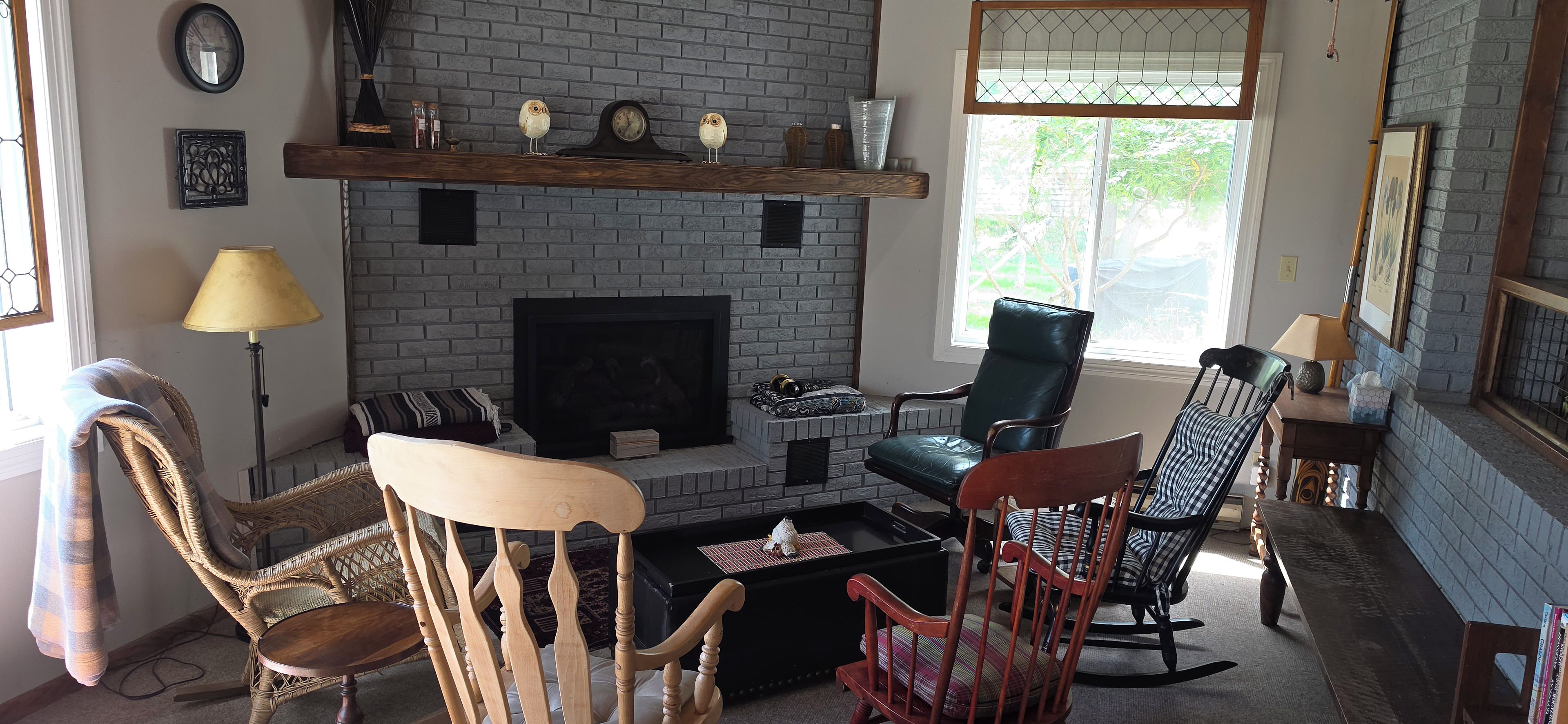 A living room with a fireplace, two chairs, a sofa, and a coffee table.
