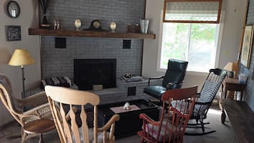 A living room with a fireplace, two chairs, a sofa, and a coffee table.