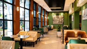 A hotel lobby with seating areas, a reception desk, and a large window offering a view of the outdoors. - Ras Hotel - Harar (Harar)