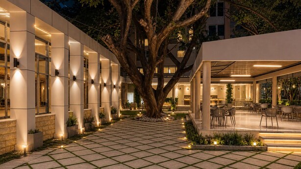 A modern building with a courtyard, outdoor seating, and a large tree. - Ras Hotel - Harar (Harar)