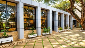 A modern building with large windows, outdoor seating, and potted plants. - Ras Hotel - Harar (Harar)