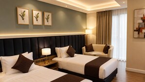 A hotel room with two beds, a sofa, a lamp, and framed artwork on the wall. - Ras Hotel - Harar (Harar)
