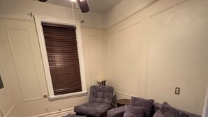A living room with a ceiling fan, a gray sofa, an ottoman, and a patterned rug. - Spacious Brooklyn 4BR/2BA Across 2 Private Floors with Yard (Brooklyn)