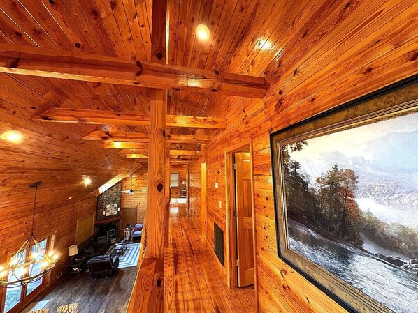 Un interior de madera con un largo pasillo que lleva a una habitación con un amplio ventanal.