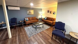 A living room with a sofa set, coffee table, and a rug. - Authentic Log Cabin • Hot Tub, Game Room & Yard Games • Sleeps 12 • Wine Country (Mount Airy)
