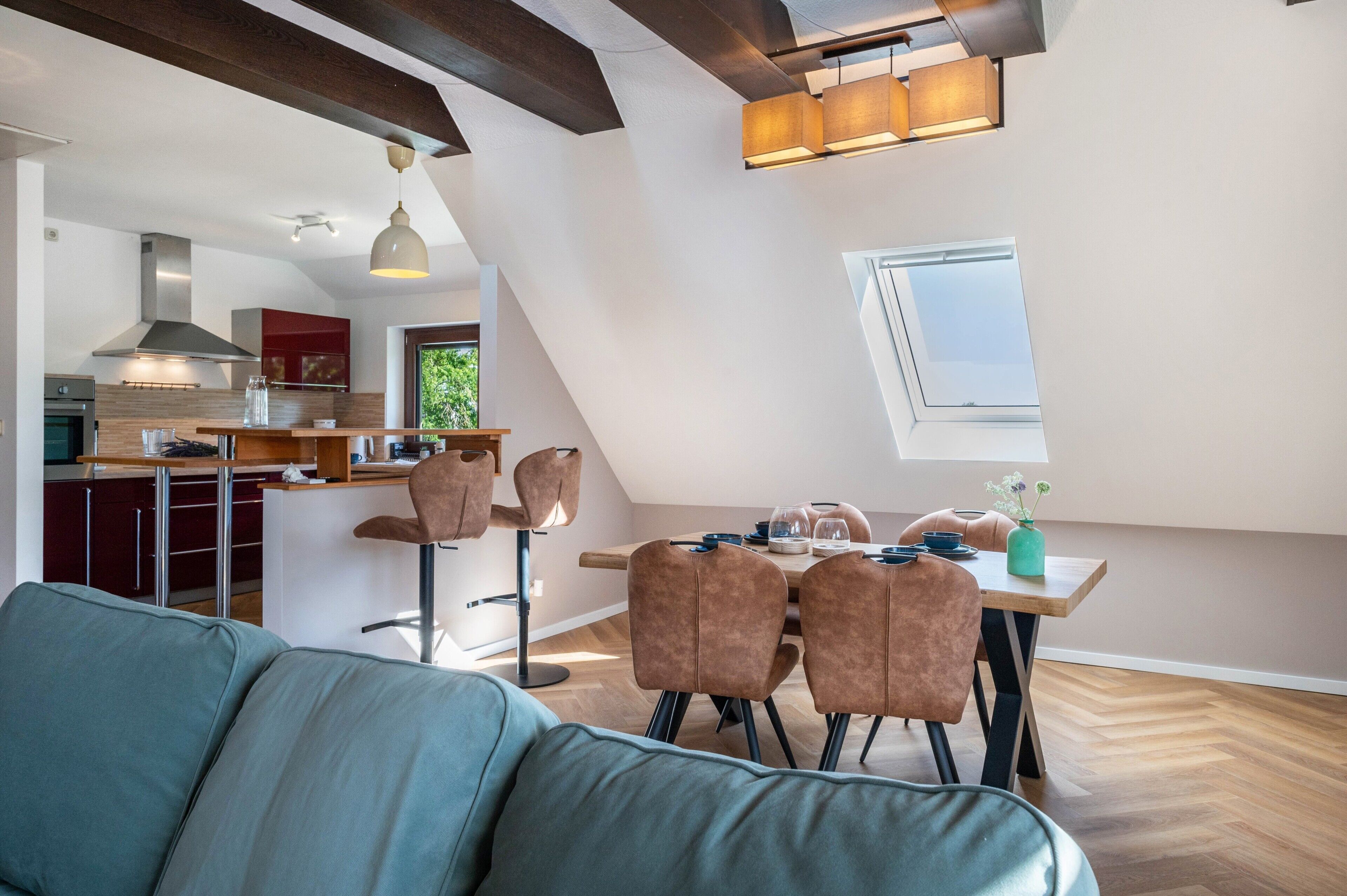 Un loft modern amb zona de menjador, cuina i una finestra gran.