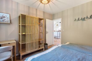 Une chambre à coucher avec un lit, une armoire en bois, un bureau et une chaise.