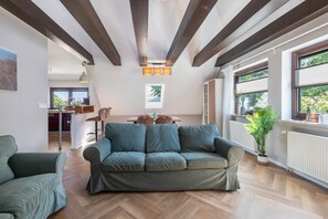 Una sala de estar moderna con un sofá, una mesa de comedor y una cocina al fondo.