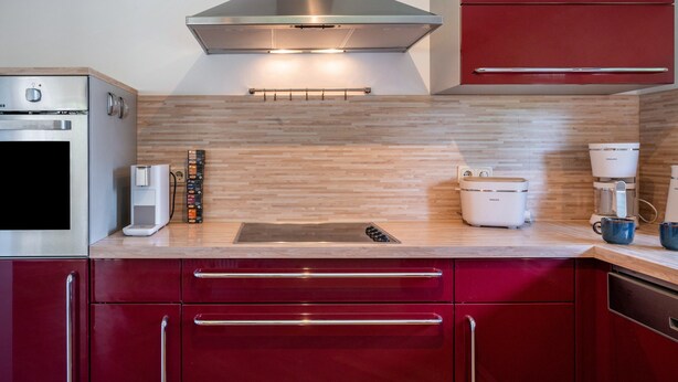 A modern kitchen with a built-in oven, a coffee maker, and a toaster. - Apartment "Kleiner Anker" with Private Terrace, Garden, and Wi-Fi (Papendorf)
