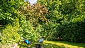 A garden with a circular fire pit and two chairs. - Apartment "Kleiner Anker" with Private Terrace, Garden, and Wi-Fi (Papendorf)