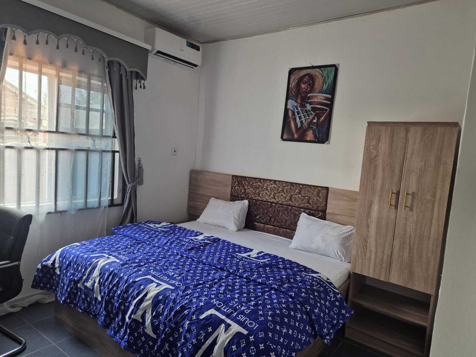Une chambre à coucher avec un lit, une chaise, une armoire et un tableau au mur.