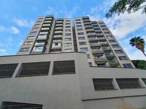 Ein Hochhaus mit mehreren Balkonen und einer glatten Fassade.