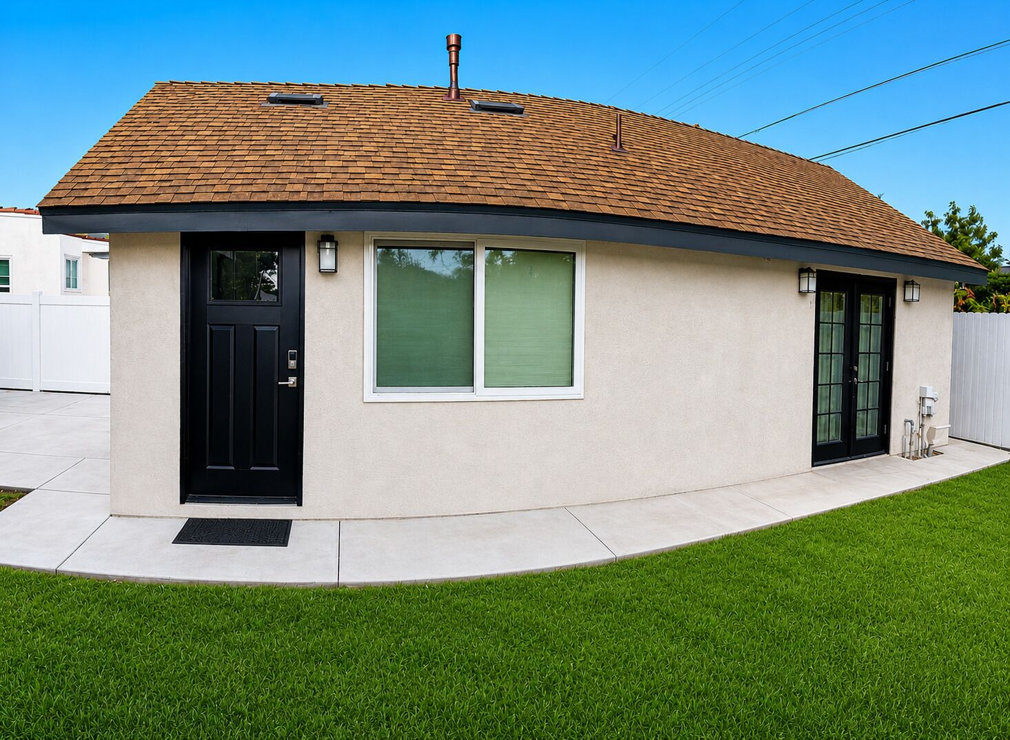 A single-story house with a curved roof, a black front door, and a small porch area.