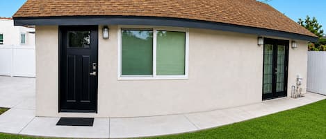 A single-story house with a curved roof, a black front door, and a small porch area.
