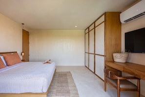 A bedroom with a bed, a desk, and a TV. - Luxury 3BR Condo at Aflora in Aldea Zama (Tulum)