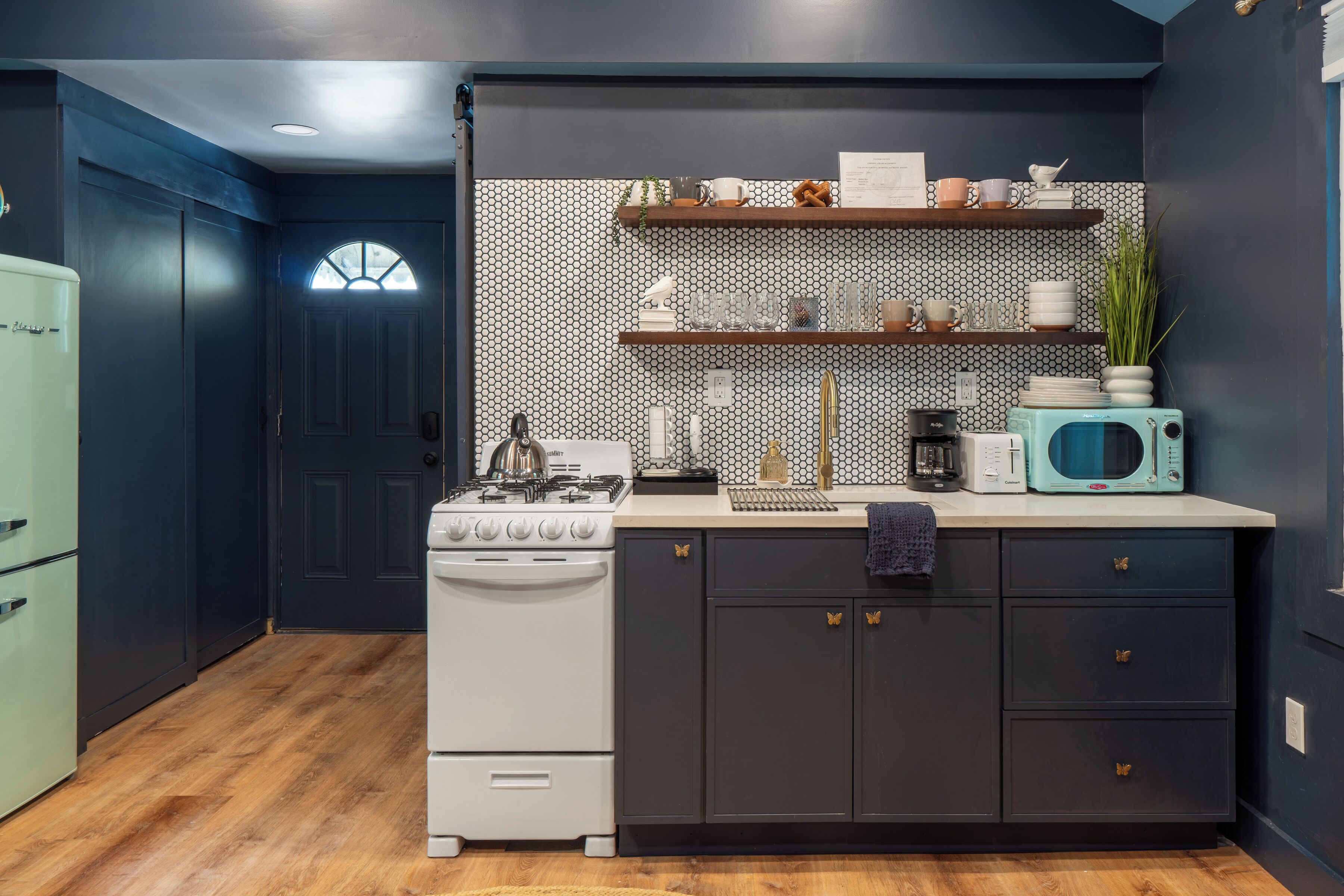A kitchen with a stove, cabinets, and a microwave.
