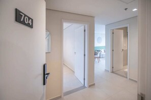 A hallway with a door labeled '704' leading to a room with a dining area. - Corporate Stays First Living - 704 (Asunción)