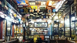 A vintage bar with a checkered floor, multiple stools, and a counter with various items. - Skyline & Sea (Belfast)