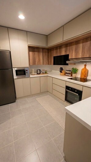 A modern kitchen with a stainless steel refrigerator, microwave, and dishwasher.