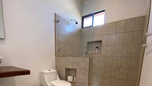 A bathroom with a toilet, bidet, and shower area. - Huella Cottage on Hilltop Views - Saltwater Pool (Cabo Velas)