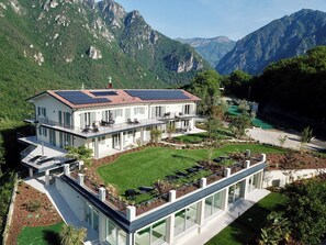 A modern two-story house with a flat roof, solar panels, and a large glass conservatory. - Apartment 8 – Palermo (Tremosine sul Garda)