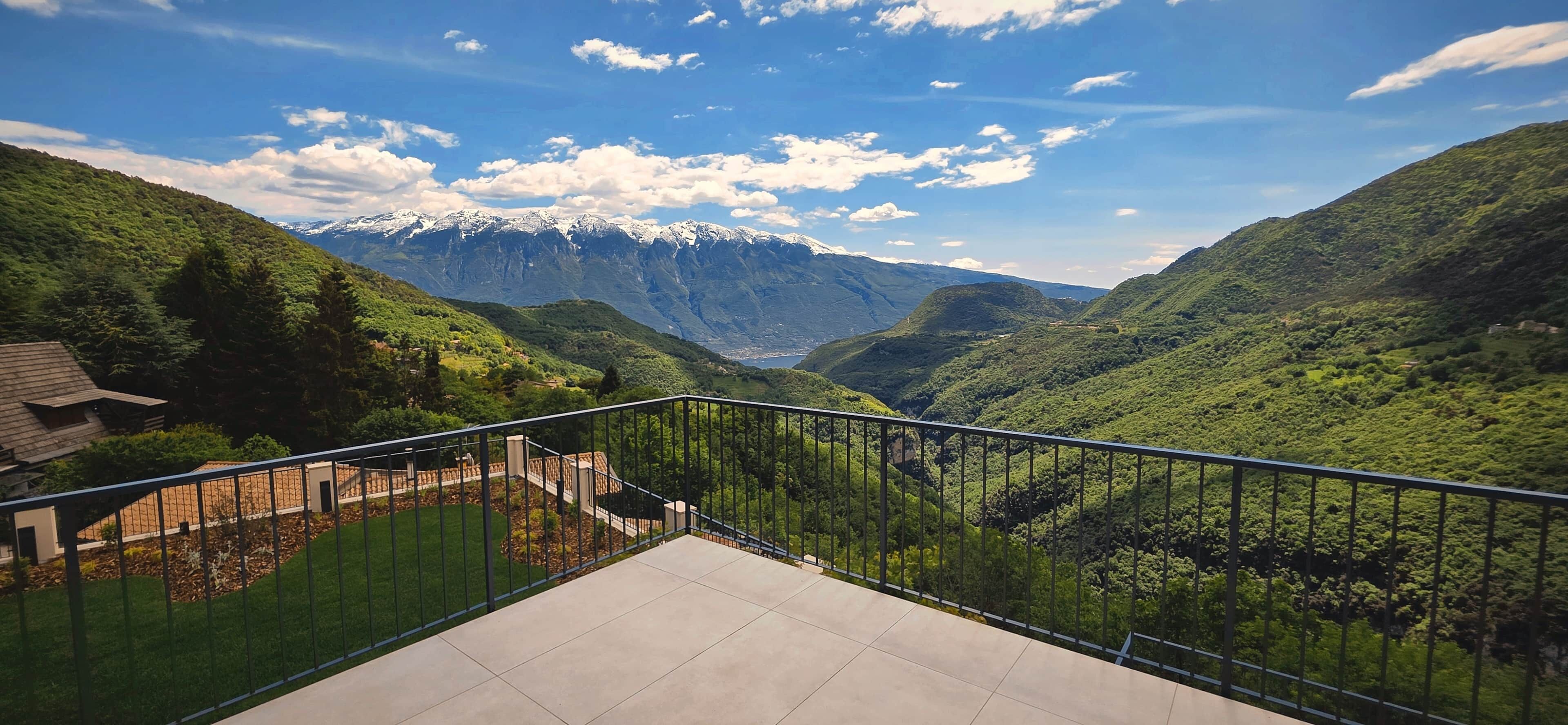 A balcony with a view of a valley and mountains.