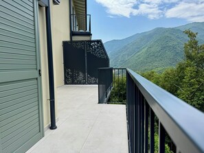 Ein Balkon mit Blick auf eine gebirgige Landschaft.
