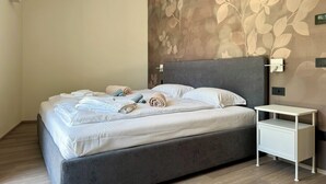 Ein modernes Schlafzimmer mit einem großen Bett, einem Nachttisch und einer Wandleuchte.
