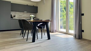 Una cuina moderna amb armaris grisos, una taula de dinar de fusta i dues cadires.