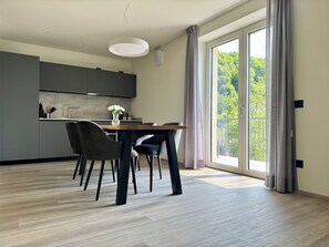 Eine moderne Küche mit grauen Schränken, einem Holztisch und zwei Stühlen.