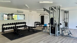 Un gimnàs amb equip d'halterofília, bancs i un mirall.