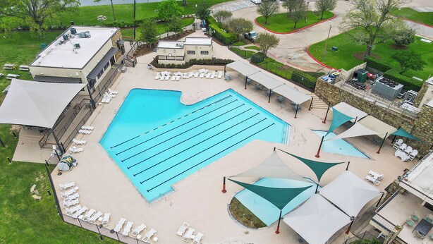 Una piscina con tumbonas, una zona de estar cubierta y un pequeño jacuzzi.