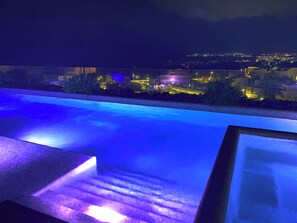 A swimming pool with a view of a cityscape at night. - Spacious 3-bedroom apartment in beautiful Cancún with AC, Gym and rooftop Pool (Cancún)