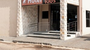 Un hotel llamado 'Hotel Entre Rios' con una fachada moderna, una entrada visible y una escalera que conduce a la entrada.
