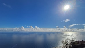 Un ciel dégagé, une mer calme et des nuages à l’horizon.