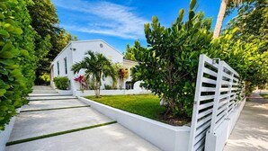 A residential property with a white exterior, a concrete pathway, and a gated entrance. - Home Private Pool • Next from the Design District (Miami)