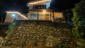 Una casa de dos pisos con una escalera de piedra que lleva a la entrada.