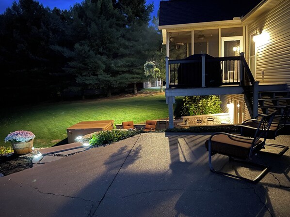 A house with a covered porch, outdoor seating, and a well-maintained lawn.
