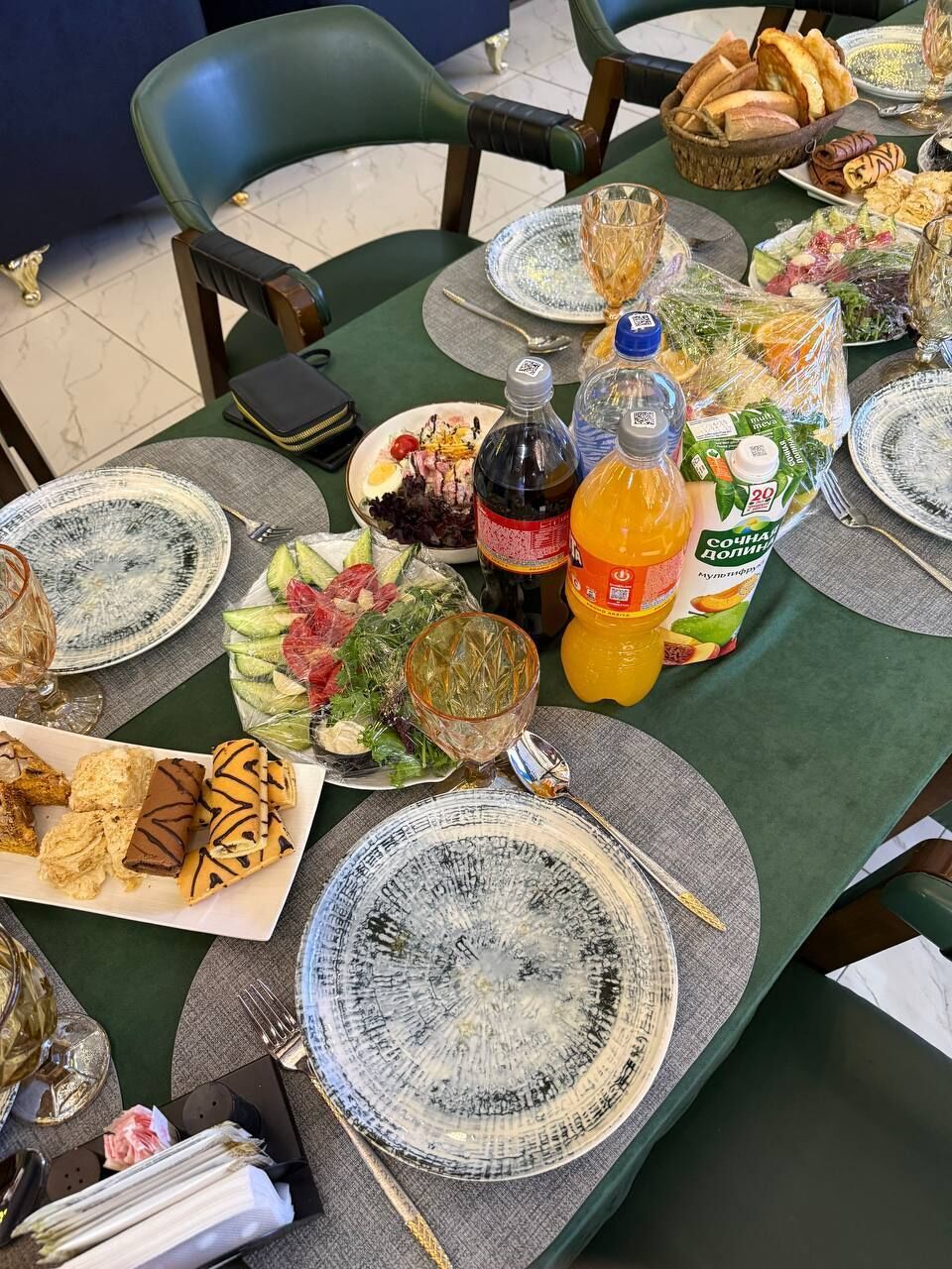 Una mesa dispuesta con platos, vasos y diferentes alimentos, indicando un ambiente para comer.