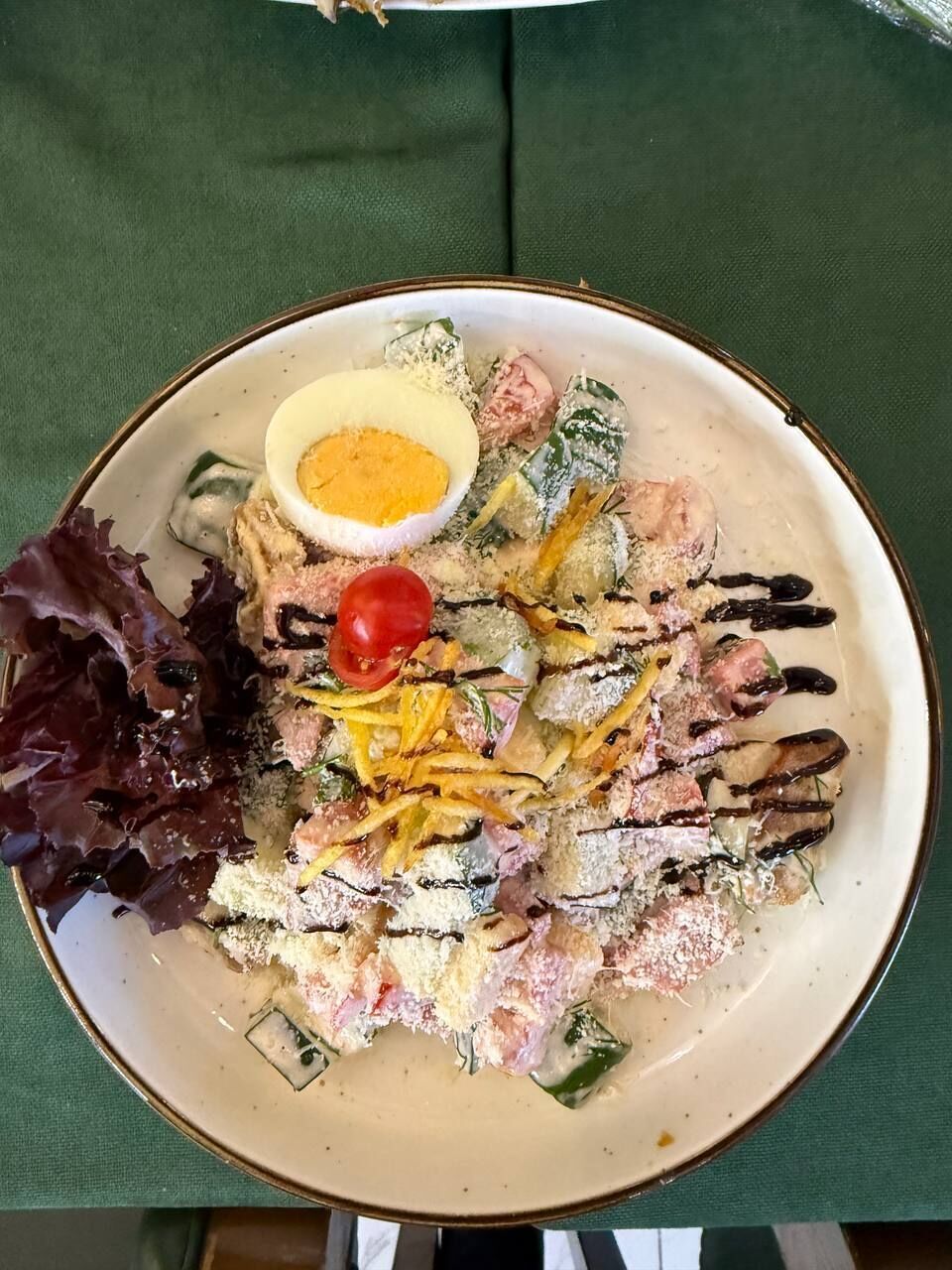 A plate with a salad, a boiled egg, and a side of greens.