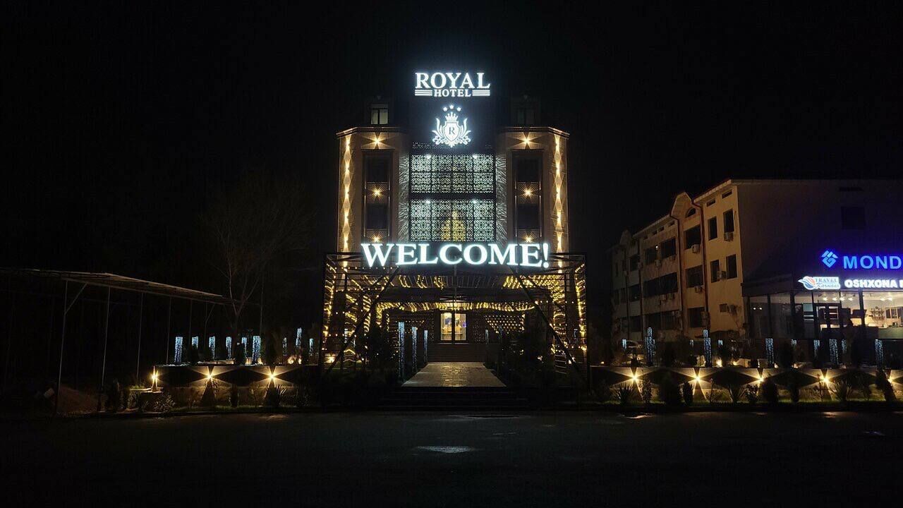A hotel entrance with a 'WELCOME!' sign, a crown emblem, and a digital display.